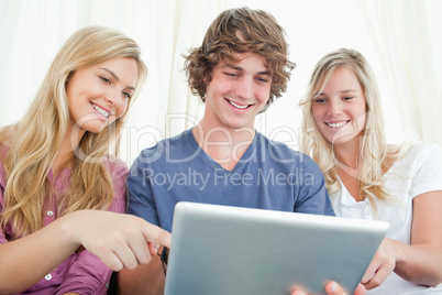 Three friends looking at the screen of the tablet