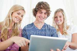 Three friends looking at the screen of the tablet