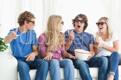 Friends laugh and joke around while watching a movie