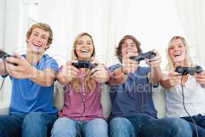A group of friends all playing video games together and smiling