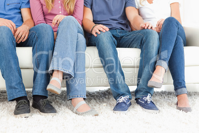 Four people sitting on the couch with the camera focused on the
