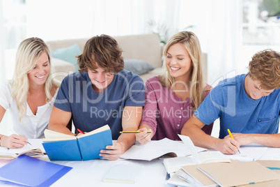 Four smiling students helping each other