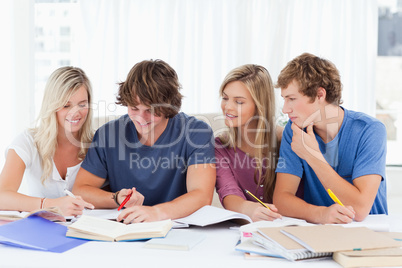 Four students sitting together and trying to get the answer