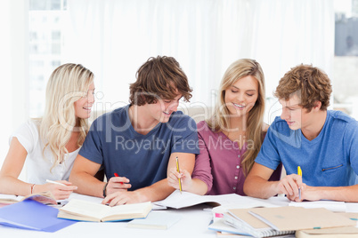 Four students laughing as they work together