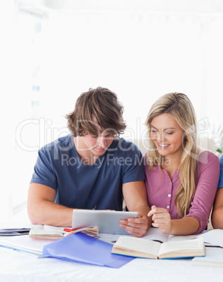 A couple look at a tablet together while smiling