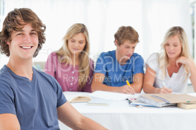Close up of a smiling man sitting in front of his friends