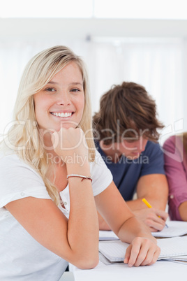 Close up of a smiling girl with her friends as she looks at the