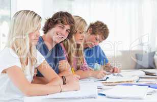 Students studying together with one man looking at the camera an