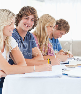 Close up of a smiling student with friends looking at the camera