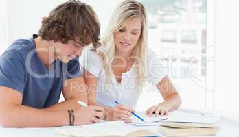 A man and woman working together at doing homework