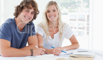 Smiling couple of students looking at the camera