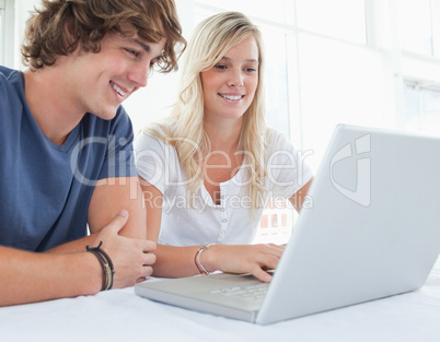 A group of smiling friends looking at the laptop