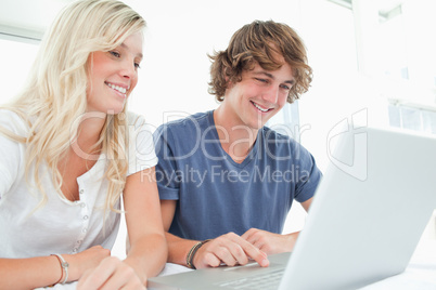 A smiling couple looking at the laptop together