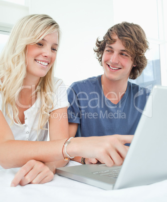 Close up of a man looking at a woman as she points at the screen
