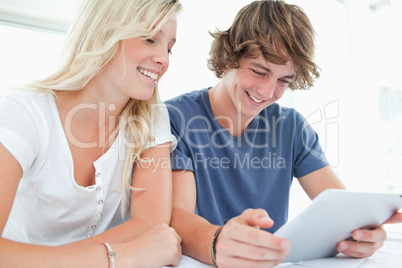 A smiling couple using a tablet together