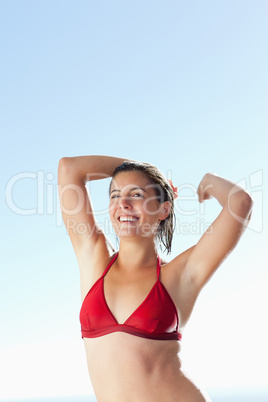 Smiling woman in bikini stretching
