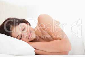Woman lying in bed, head on pillow, sleeping,