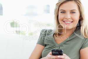 Woman smiling and holding her phone