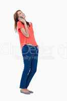 Relaxed teenage girl tilting her head while makng a call