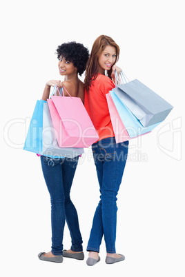 Smiling teenagers looking behind them after shopping