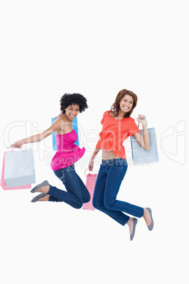 Young teenagers energetically jumping after going shopping