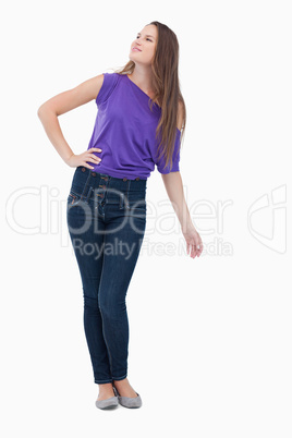 Teenager looking far ahead to her side with her hand on her hip