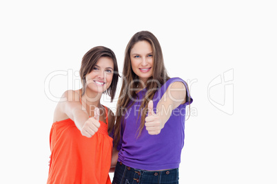 Happy teenagers putting their thumbs up in approval