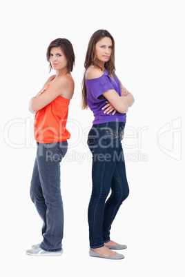 Teenage girls wearing casual clothes while standing back to back