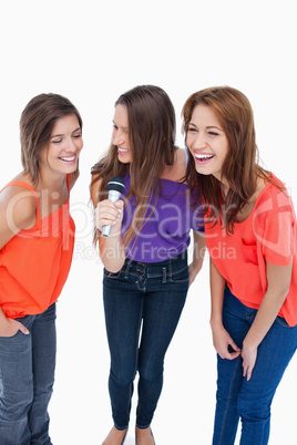 Teenagers laughing while singing karaoke