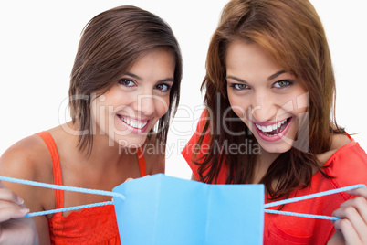 Two teenage girls holding a purchase bag while smiling