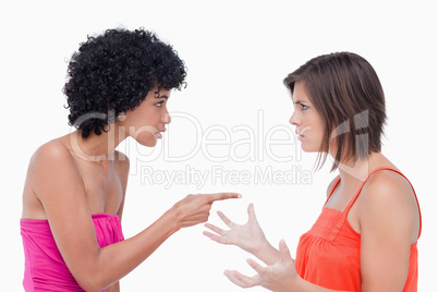 Teenager blaming a friend pointing her finger on her