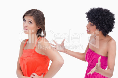 Upset teenager roaring at a friend against a white background