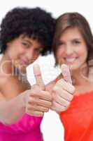 Thumbs up showed by two happy teenage girls