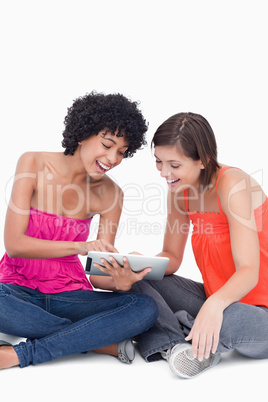 Teenage girl showing a funny application on her tablet PC to a f