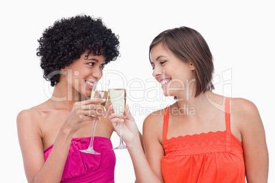 Young women clinking glasses of champagne while smiling