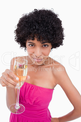 Young woman holding a glass of champagne while looking at the ca
