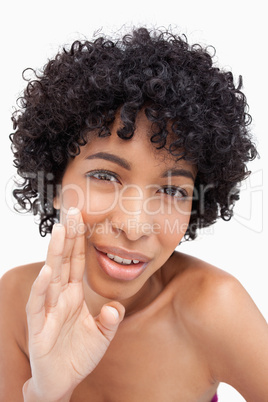 Young woman whispering against a white background