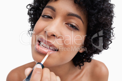 Young woman applying lipstick in a concentrated way