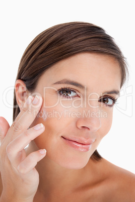 Teenager applying cream on her face with her fingers