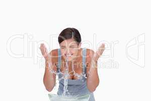 Teenager standing behind a bowl of water while splashing