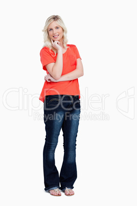 Smiling teenager standing with her finger on her cheek