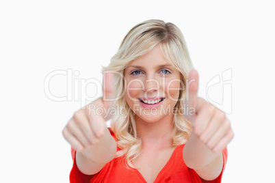 Attractive young woman showing her thumbs up in front of her