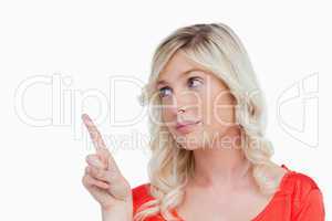 Young woman pointing something in the air with her finger