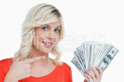 Smiling woman pointing at her dollar notes with her finger