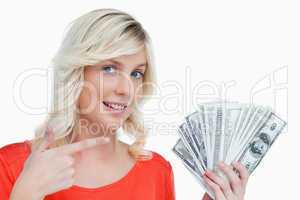 Smiling woman pointing at her dollar notes with her finger