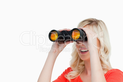 Smiling attractive woman looking with binoculars
