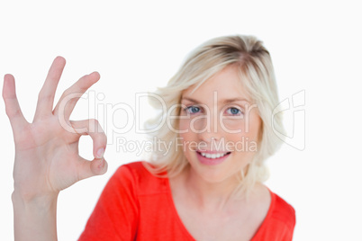 Young blonde woman showing the OK sign in front of the camera
