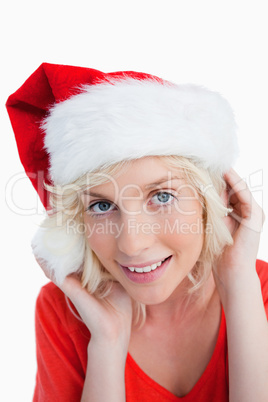 Young blonde woman putting on the Santa Claus hat