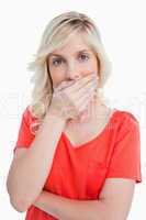 blonde woman covering her mouth with her hand