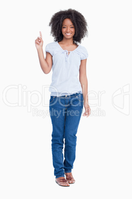 Smiling young woman raising her finger in the air